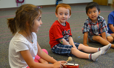 Three children play glockenspiels