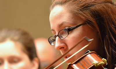A close up of an adult playing violin