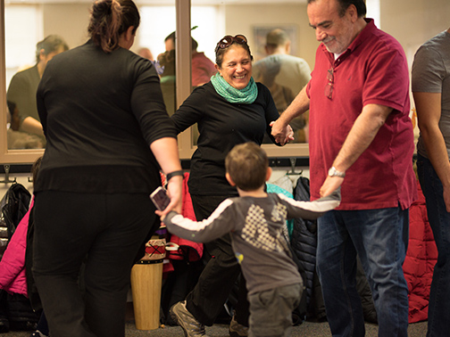 A family dances in a circle smiling