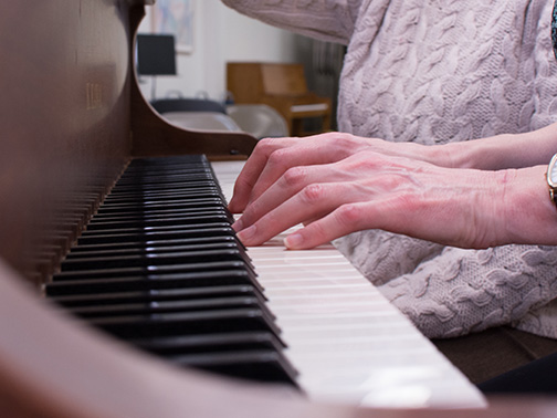 Close up of an adult's hands playing the piano