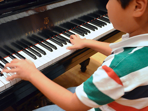 A young student plays the piano