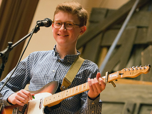 A young student plays the guitar